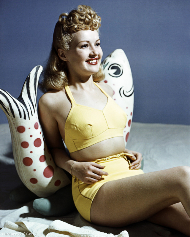 Így pózolt Betty Grable amerikai táncosnő és énekesnő sárga kétrészes fürdőruhában az 1940-es években. 