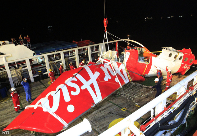 Az indonéz mentőalakulatok tagjai daruval emelik ki a Crest Onyx mentőhajó fedélzetéről az AirAsia malajziai légitársaság lezuhant gépe farokrészének maradványát a Jávai-tengeren