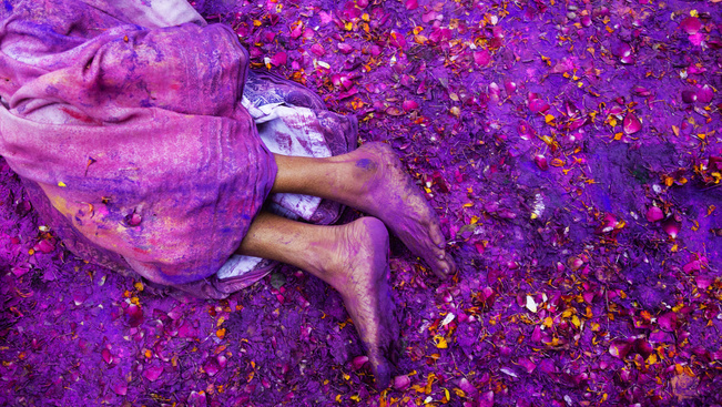 Egy hindu özvegy fekszik a földre hintett színes porfestékben, a Holi ugyanis az újjászületés szimbóluma is.