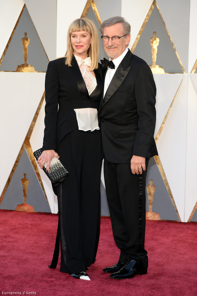 Kate Capshaw színésznő se néz ki túl csodásan férje, Steven Spielberg mellett ebben a kissé bohócos férfiszmokingban, de arra legalább jó, hogy átvezessen minket ez a kép a férfidivathoz