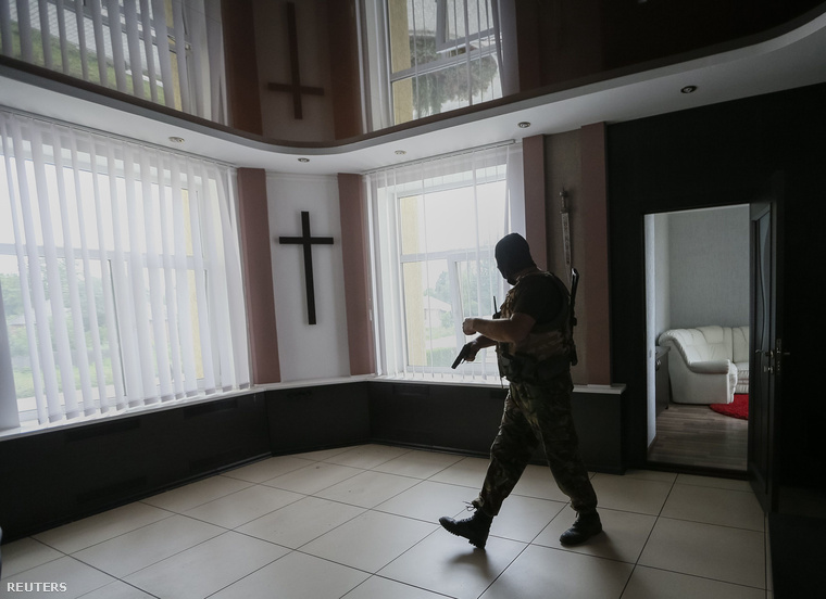 Kormánypárti fegyveres vizsgál át egy korábban szakadárok által lakott épületet Szlvajanszk közelében