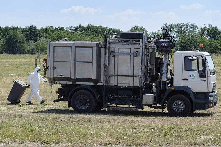 Az ATEV Fehérjefeldolgozó Zrt. munkatársa dolgozik egy állatimelléktermék-begyűjtő jármű mellett egy Tiszafüred-Kócsújfalu közelében található szarvasmarhatelepen 2014. július 4-én.