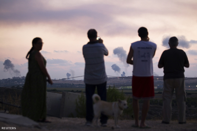 Izraeli telepesek figyelik a légitámadás okozta füstoszlopokat Gáza északi határában