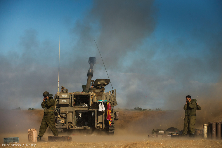 Izraeli katonák egy tüzérségi ágyúval lőnek a gázai övezet határánál, 2014. július 17-én.