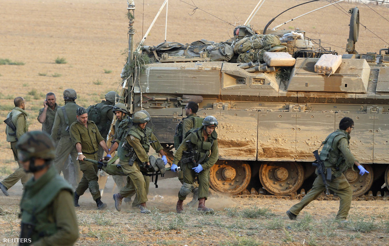 Izraeli katonák szállítanak egy sebesültet a gázai övezetben vasárnap délután