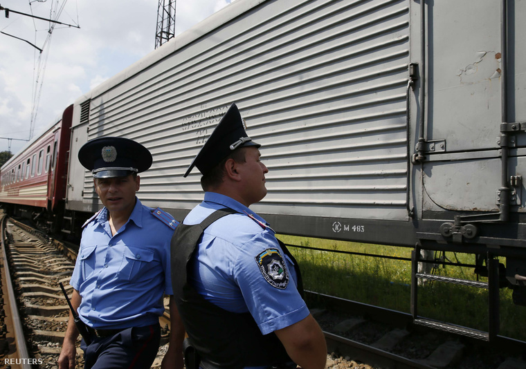 Ukrán rendőrök őrzik Harkovban a malajziai utasszállító áldozatainak maradványait szállító hűtőszerelvényt, 2014. július 22-én.