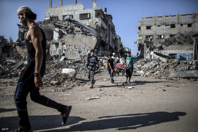 Palesztinok kutatják át a romokat egy izraeli rakéta becsapódásának helyén, július 27-én