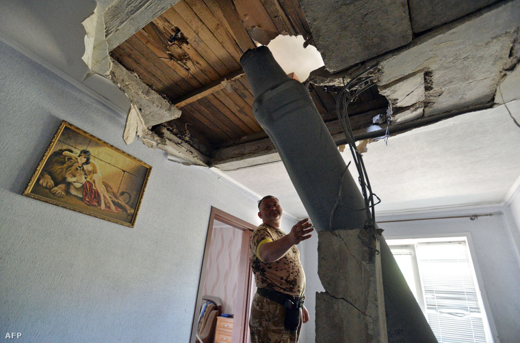 Egy házába csapódott, fel nem robbant orosz rakétát vizsgál egy ukrán férfi július 27-én