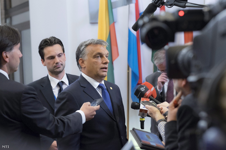 Orbán Viktor újságíróknak nyilatkozik az EU-országok állam- illetve kormányfőinek csúcstalálkozója után 2014 június 27-én. A kormányfő mögött Havasi Bertalan.