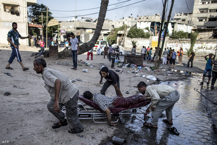 Palesztin sebesültet szállítanak el az utcáról Gázában, július 30-án