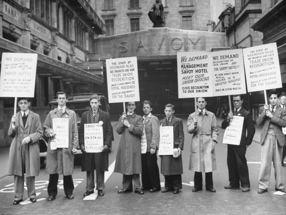 A hotel dolgozóinak szakszervezete tüntet a hivatalos elismerésért az épület előtt 1946-ban. Azzal érvelnek, hogy ha a Buckingham Palota dolgozóinak szakszervezetét elismeri a munkáltatója, akkor a Savoy dolgozóinak is joguk van hozzá hogy tárgyalhassanak a hotel vezetésével - ez az összehasonlítás önmagában is árulkodik a szálloda státuszáról. 