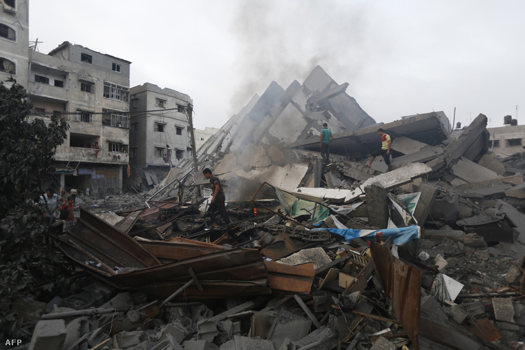 Palesztin lakosok az épület maradványai között Gázában, 2014. augusztus 26-án.