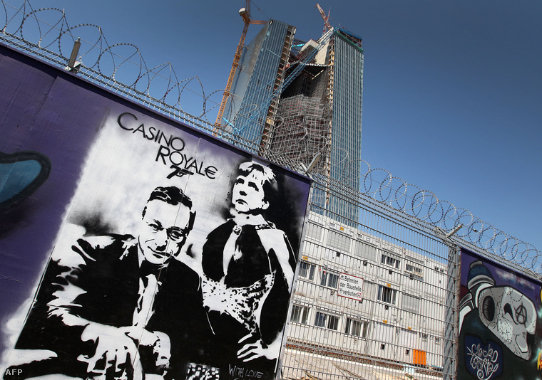 Egy graffiti Mario Draghival és Angela Merkellel az EKB új épületének építési területe körüli falon.