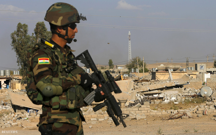Kurd katona egy épület előtt, amit az éjszakai légi csapás során bombáztak