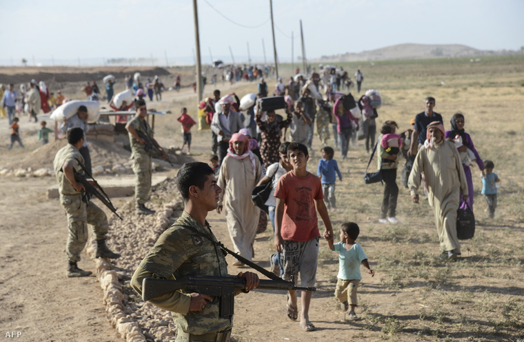 Menekülő kurdok a határátlépés után, a Sanilurfa tartománybeli Suruc város közelében, 2014. szeptember 19-én.