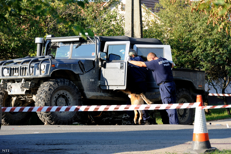 A baleset helyszínén rendőrök kábítószer-kereső kutyával vizsgálnak át egy Hummer terepjárót, 2012. október 11-én.