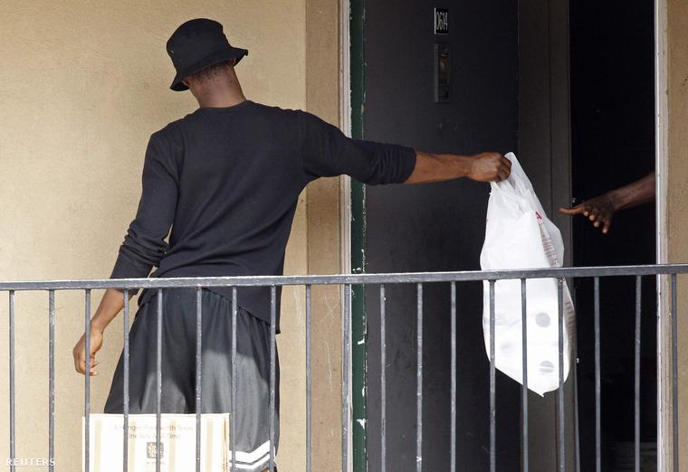 Élelmiszersegélyt ad be az ajtón egy futár abba a hotelszobába, ahol az ebolával fertőzött amerikai férfi tartózkodott