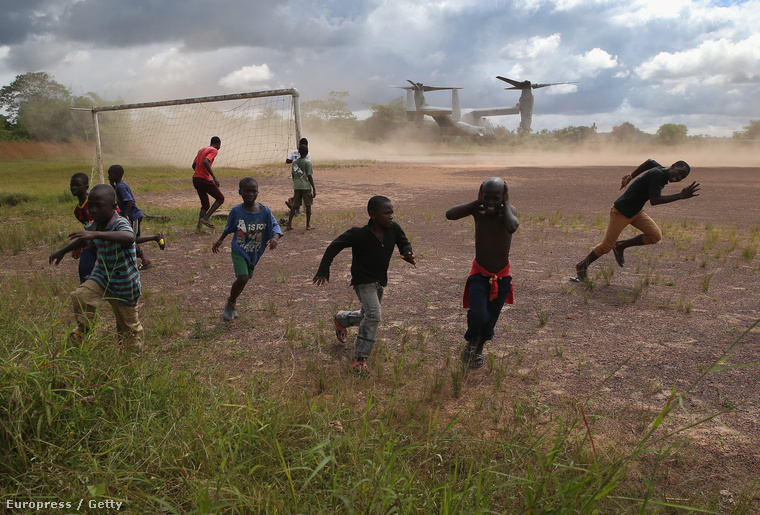 Libériai gyerekek szaladnak az amerikai hadsereg szállítógépe kavarta por elől