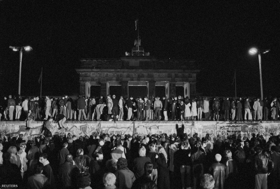 Együtt ünneplik a kelet- és nyugatnémetek a 
                        határnyitást a Brandenburgi kapunál. A párt vezetése leváltotta az NDK évtizedek óta államfő-párttitkárát, Erich Honeckert, utódja Egon Krenz lett. Végül a keletnémet vezetés a határok megnyitásáról döntött, amit a tervezettnél egy nappal korábban, 1989. november 9-én jelentettek be.