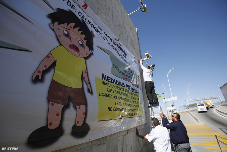 Kanyaró megelőzését célzó programról szóló plakátot helyez ki egy munkás a mexikói határon, El Paso, 2015. február 16.