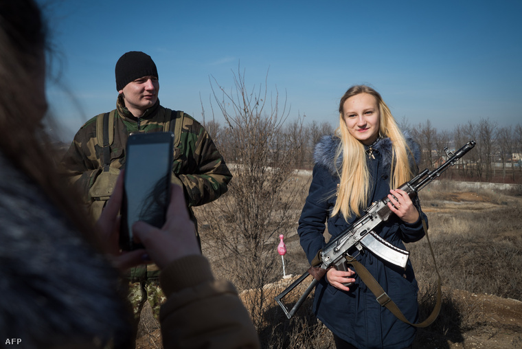 Egy oroszpárti szeparatista fegyverével pózol egy ukrán lány Donyeckben.