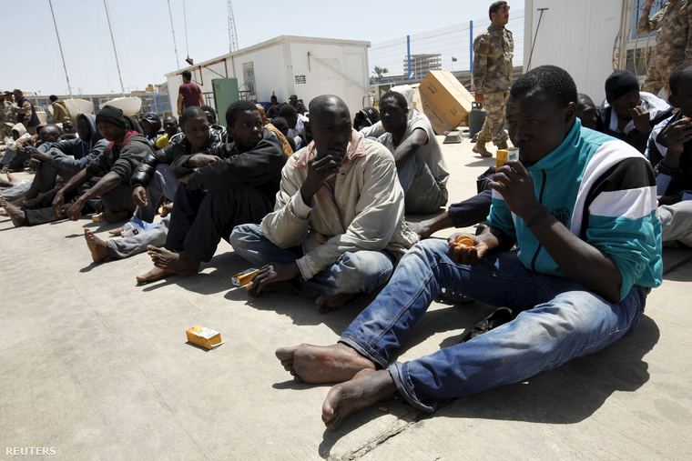 Földközi-tengerről visszafordított menekültek várakoznak Tripoli kikötőjében, Líbiában