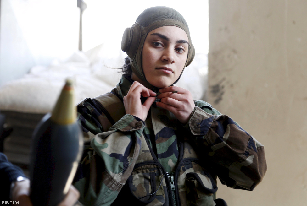 A szíriai hadsereg Női Kommandós Zászlóaljának egyik tagja járőrözésre készül a kormányerők által ellenőrzött Jobarban, Damaszkusz egyik külvárosában.
                        A szíriai hadseregnek 800 női katonája van, egy részüket a közelmúltban toborzta a kormány, hogy “elősegítse a nők emancipációját”. Sokak szerint ez csak egy PR-fogás, amellye Bassár el-Aszad szíriai diktáror a nyugatiaknak akarja megmutatni, milyen haladó és modern felfogású uralkodó. 
                        Erre utal az is, hogy a női zászlóalj létezését plakátokon hirdetik a kormány ellenőrzése alá tartozó országrészekben. Az önként jelentkező nők több hónapos kiképzésen vesznek részt, mielőtt különböző feladatokra beosztják őket a fronton. A szíriai hadsereg nem félti a nőket az éles bevetéstől, vannak köztük mesterlövészek és tankvezetők is.
                        A nők toborzásában egyébként már Aszad apja is élen járt, akinek az uralma alatt még egy női ejtőernyős hadosztály is szolgált a hadseregben, a  ’70-es években pedig nőknek és férfiaknak egyaránt részt kellett venniük katonai kiképzésen.
                        